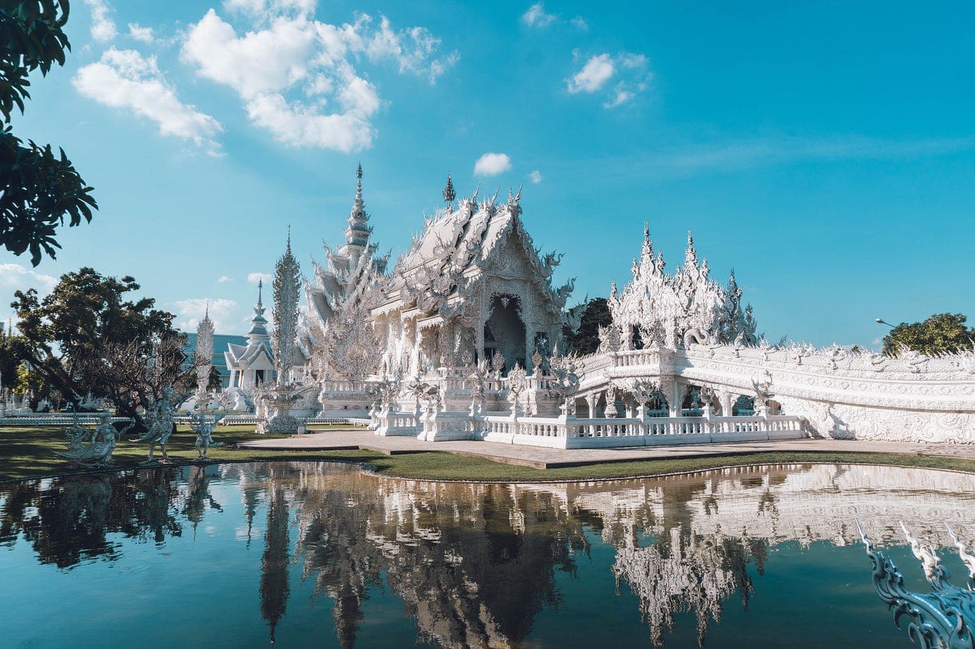 Wat Rong Khun White Temple Chiang Rai Thailand 2026 — glistening white and mirror-glass temple surrounded by reflective pool
