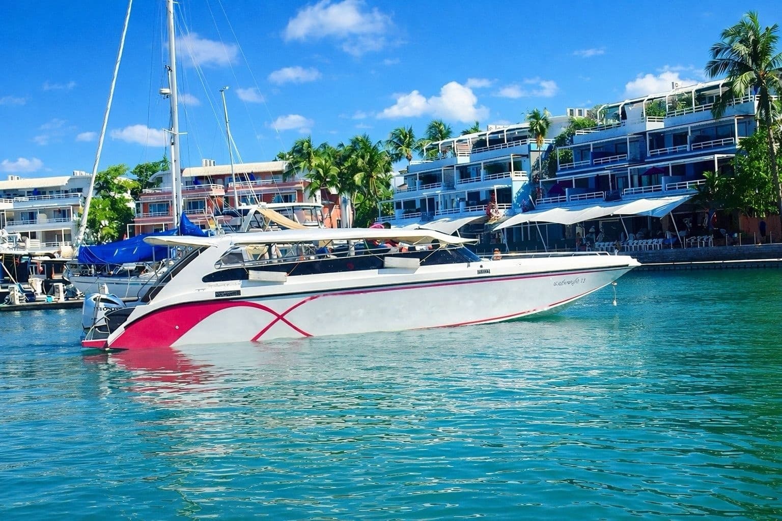 Amazing Canoeing Phi Phi speedboat with shade canopy and padded cabin seating moored at Royal Phuket Marina, Koh Kaew