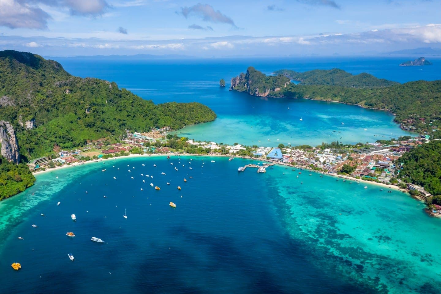 Phi Phi Islands speedboat tour from Phuket 2026 — speedboat crossing the turquoise Andaman water towards Maya Bay limestone cliffs