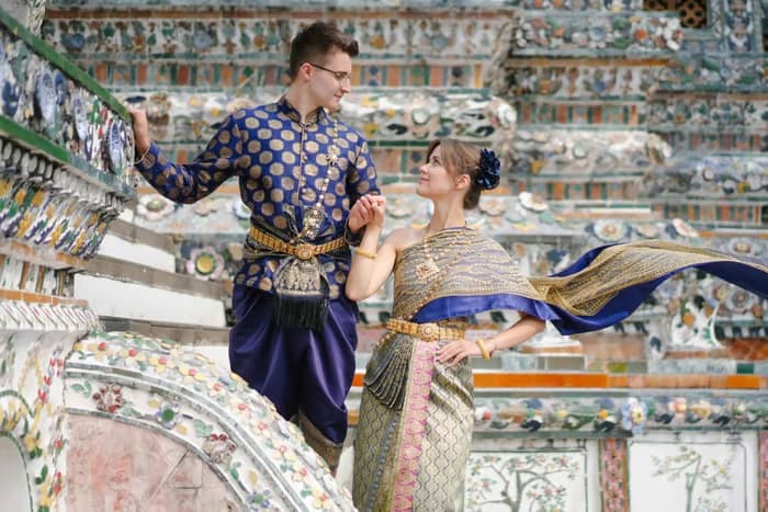Thai traditional dress Chut Thai costume photo shoot Wat Arun Bangkok temple porcelain spires