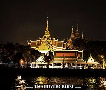 The Grand Palace illuminated at night seen from a Bangkok dinner cruise on the Chao Phraya River