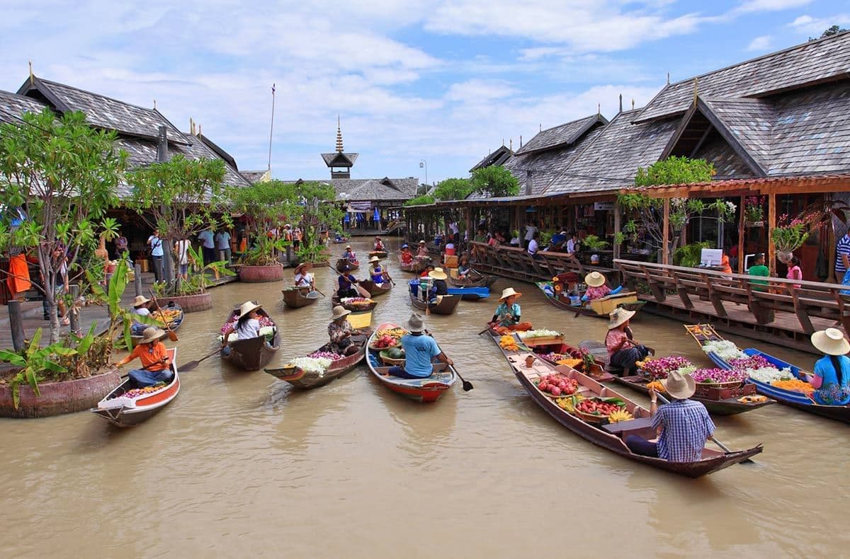 Pattaya Floating Market boat ride — traditional paddle boat gliding through the canal between stilt shops