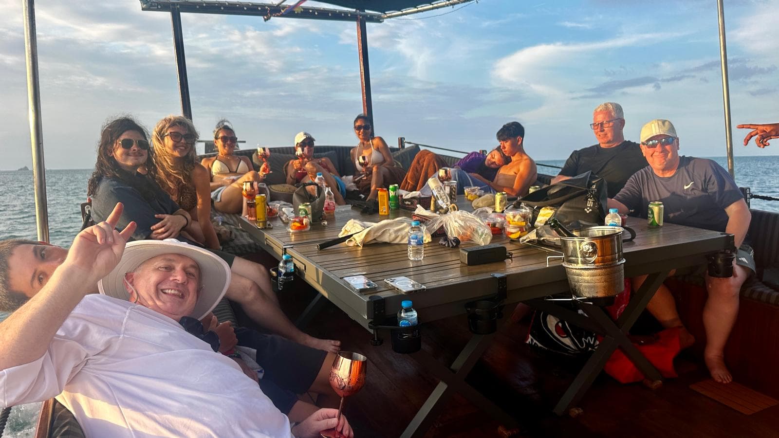 Group enjoying golden hour drinks on the Koh Samui coastal cruise wooden trawler