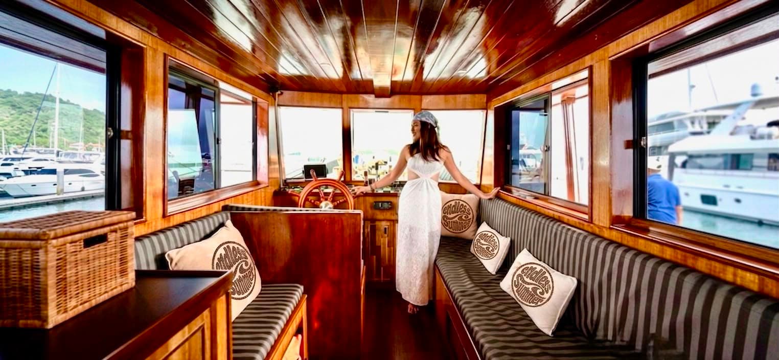 Handcrafted teak interior and helm of the Endless Summer wooden trawler Koh Samui