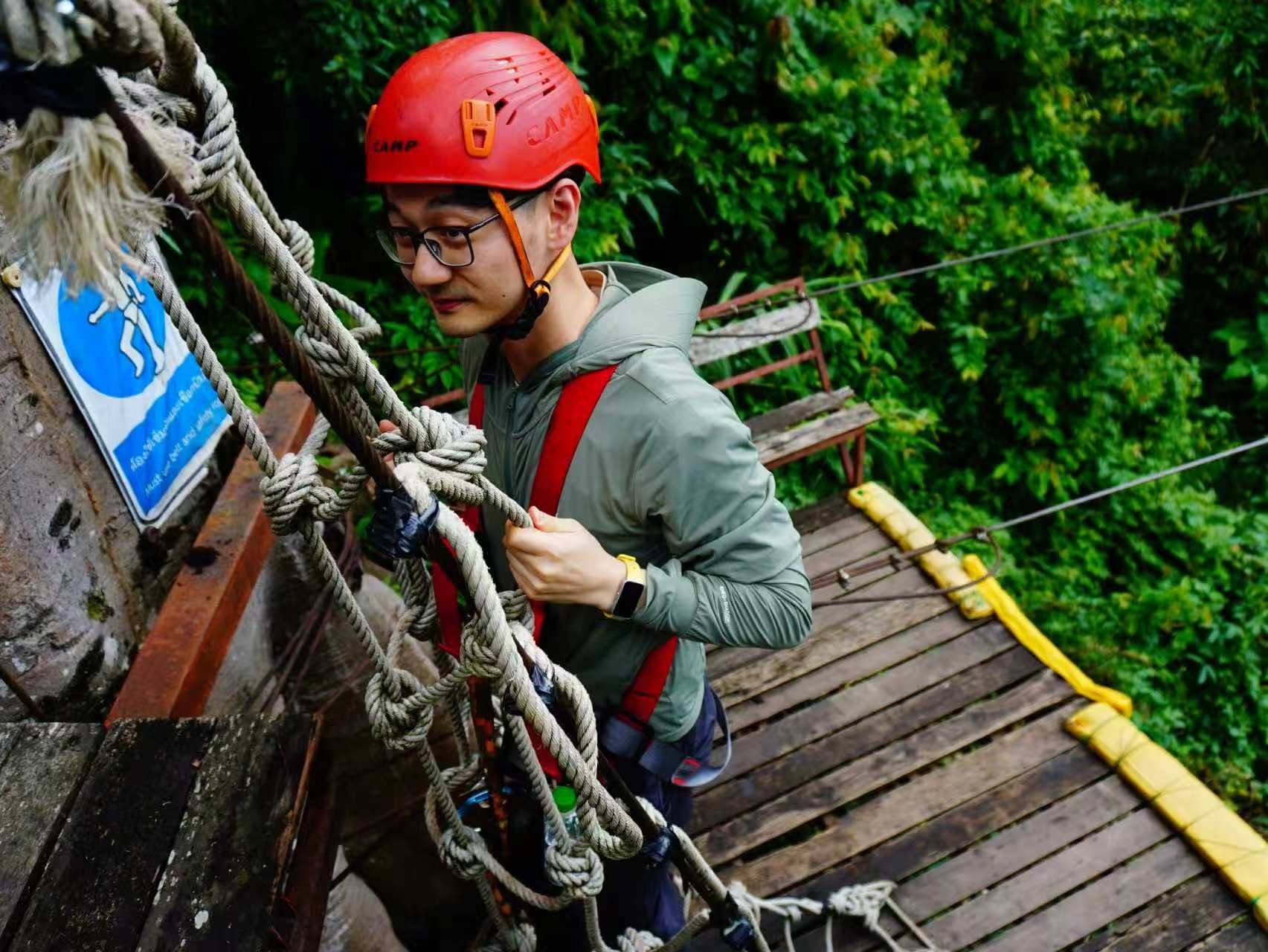 Guide checking a harness and twin carabiners before the first platform