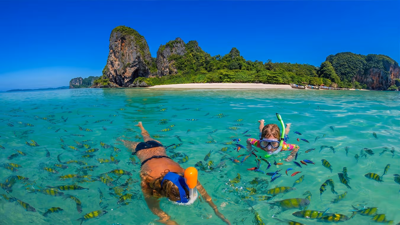 Lading Island snorkelling — bay surrounded by cliffs and trees, comfortable shade against the sun
