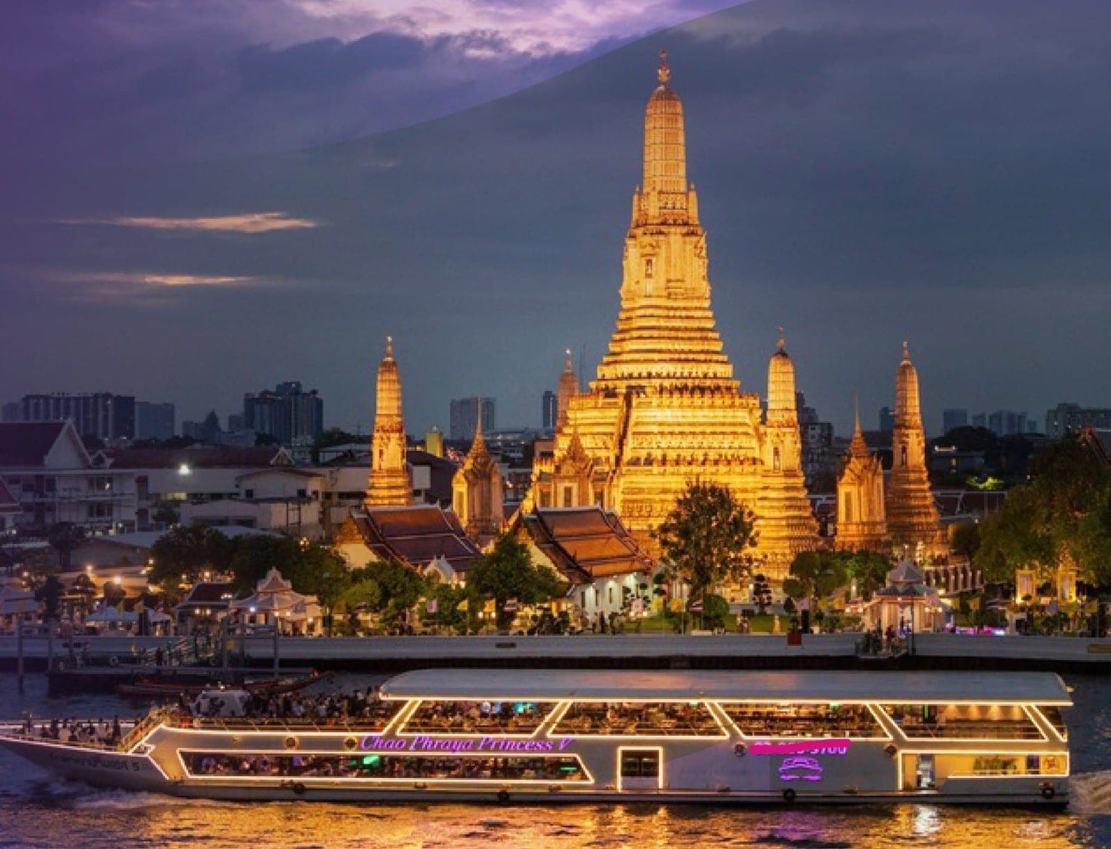 Wat Arun Temple of Dawn illuminated at night viewed from the Chao Phraya Princess cruise