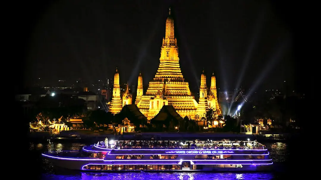 Wat Arun Temple of Dawn illuminated at night viewed from the White Orchid River Cruise