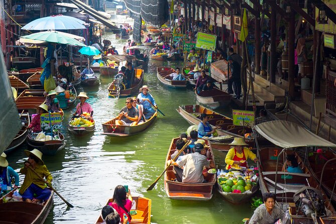 Damnoen Saduak canal morning light — paddleboat vendor selling tropical fruit floating market Bangkok