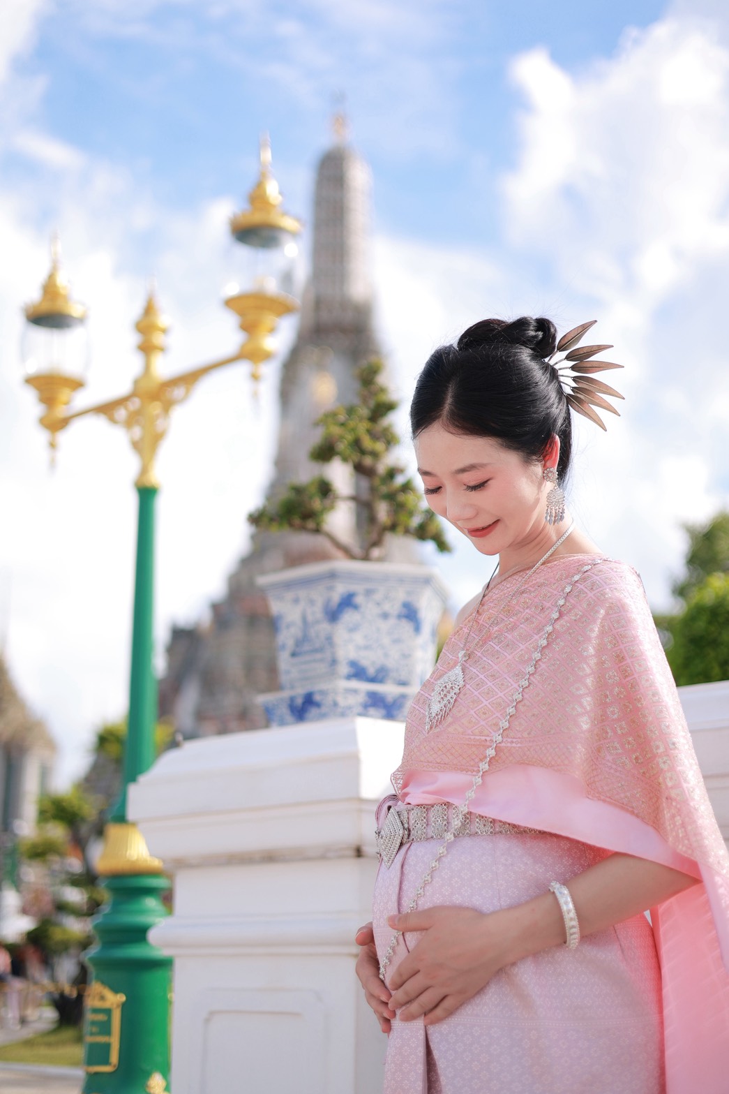 Pregnant woman in pink Thai traditional dress at Wat Arun Bangkok maternity photoshoot