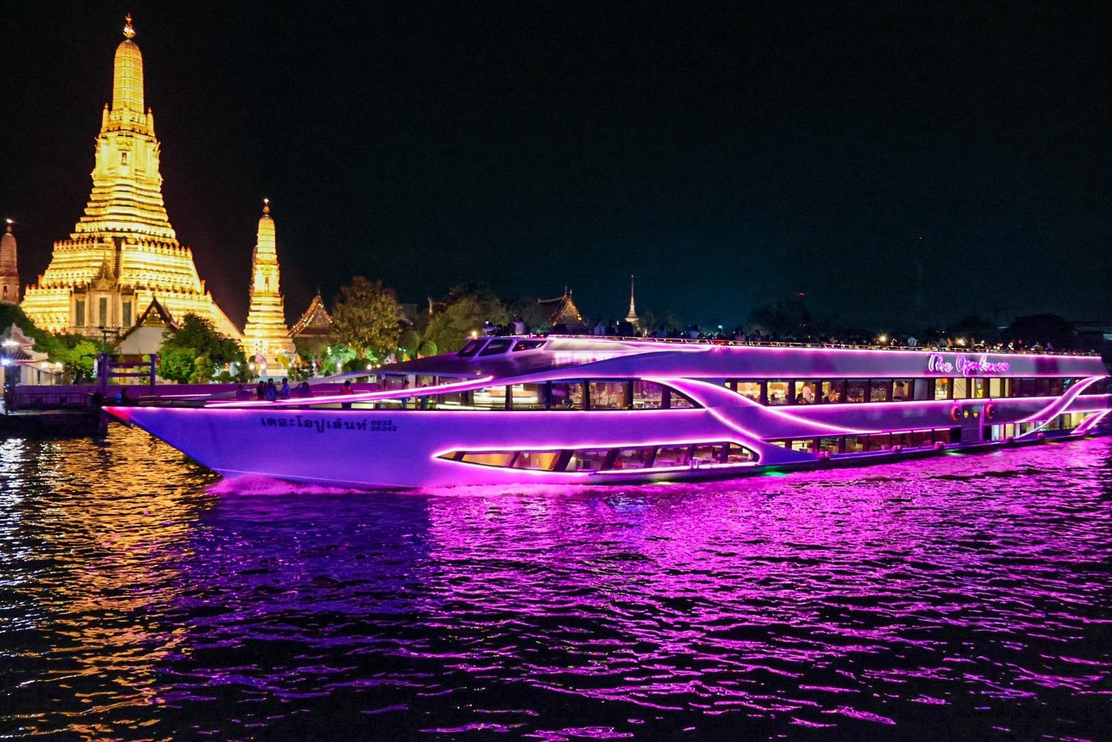 Wat Arun Temple of Dawn illuminated at night viewed from The Opulence Cruise on the Chao Phraya River